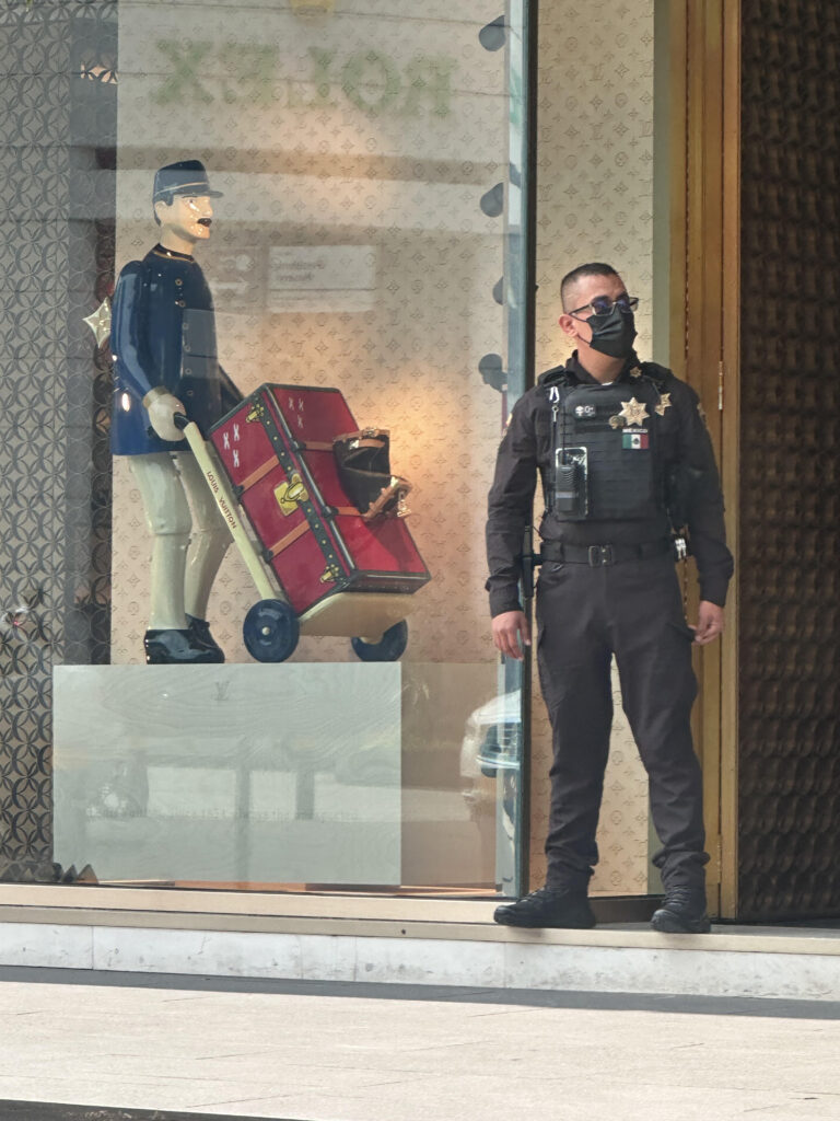 Guardia de seguridad vigilando el acceso de una tienda de lujo en México
